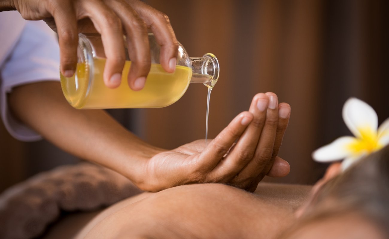  A close-up of a masseur pouring oil.